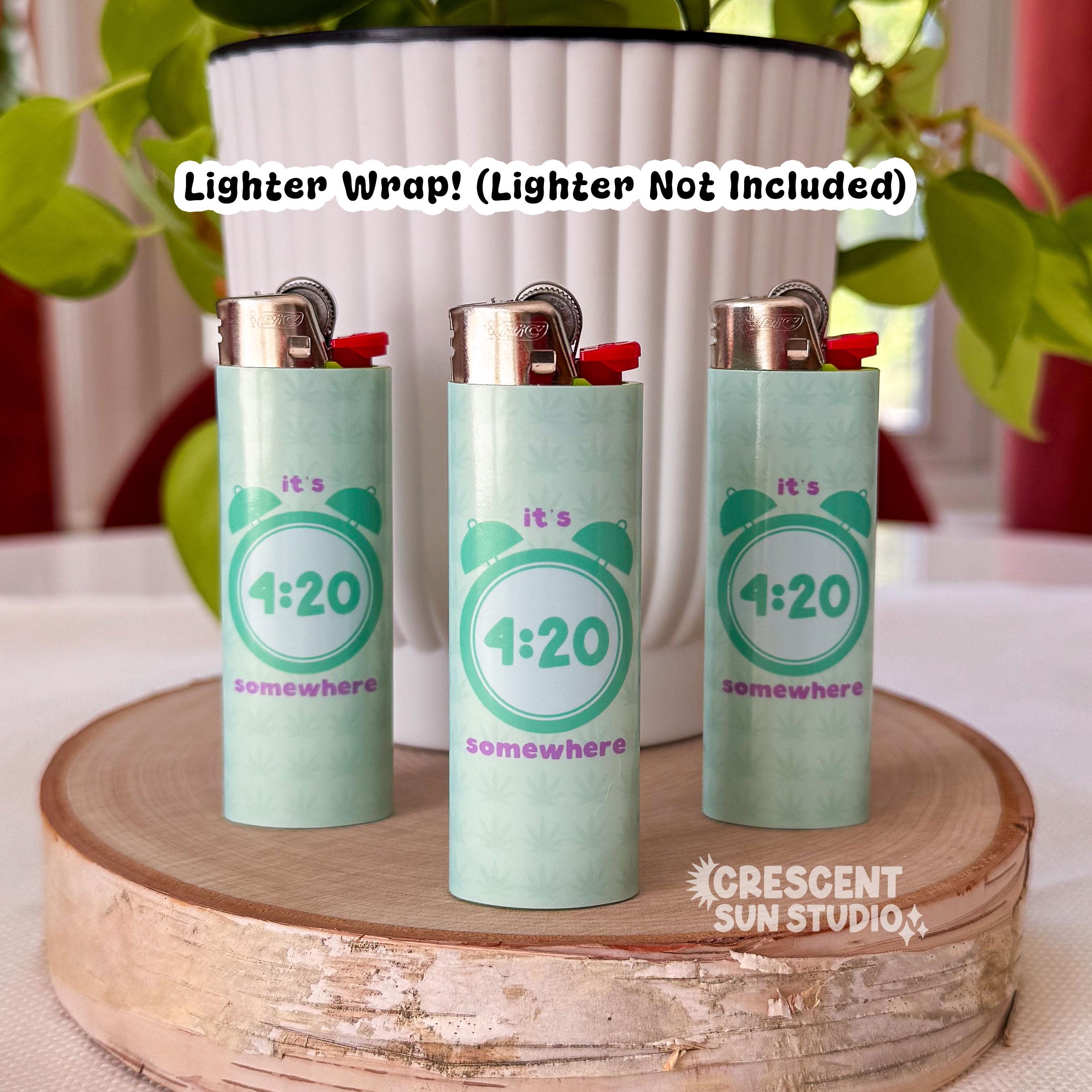 Image shows three lighters individually wrapped in our "It's 4:20 somewhere" wrap. The wrap is mint green with a darker mint green alarm clock that displays the time of 4:20. Above the clock it reads "it's" and below the clock it says "somewhere."

Over the entire image there is text that reads Lighter wrap! Lighter not included