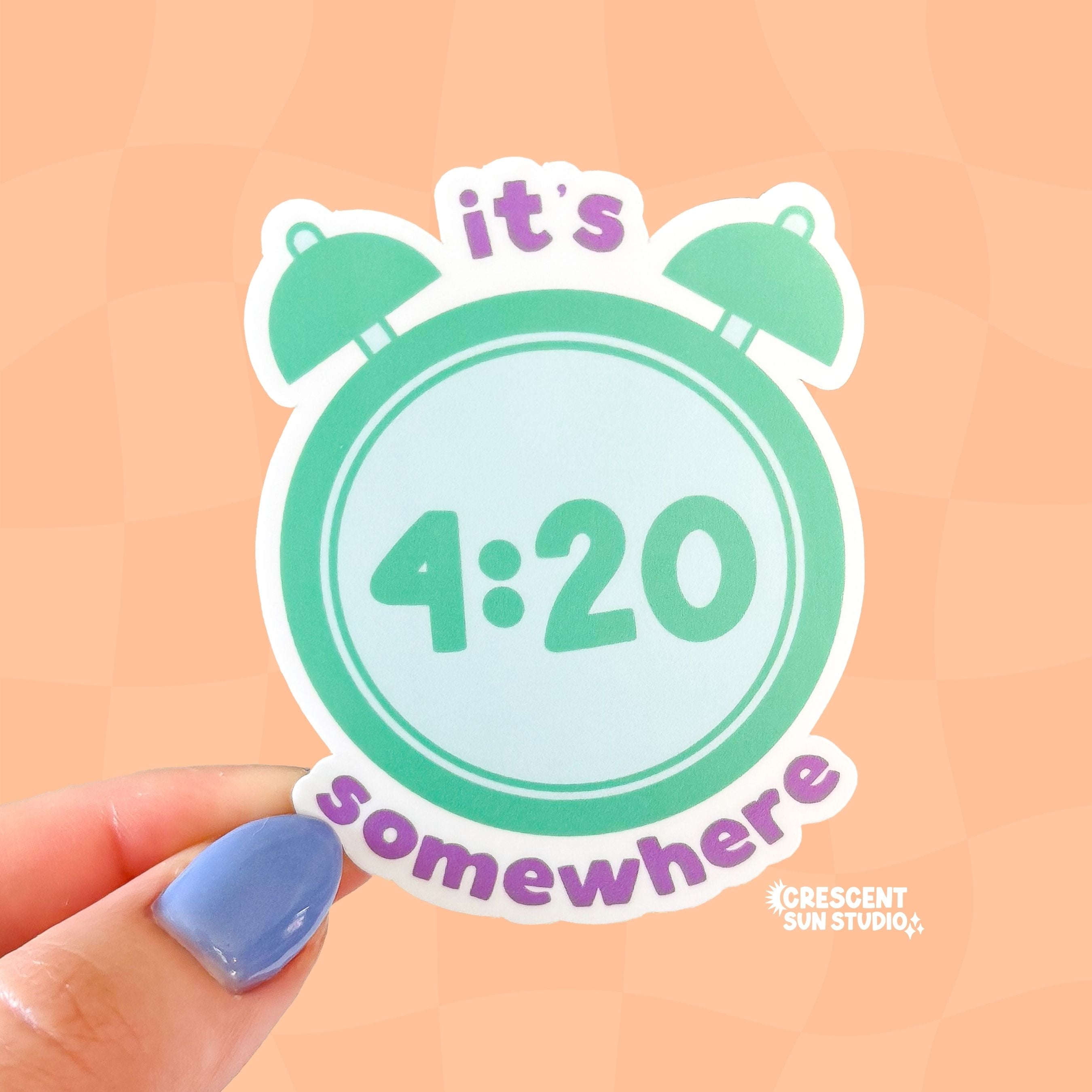 A die cut sticker of a mint green alarm clock with the time that reads 4:20. Purple lettering above and below the clock make the message spell out "it's 4:20 somewhere"