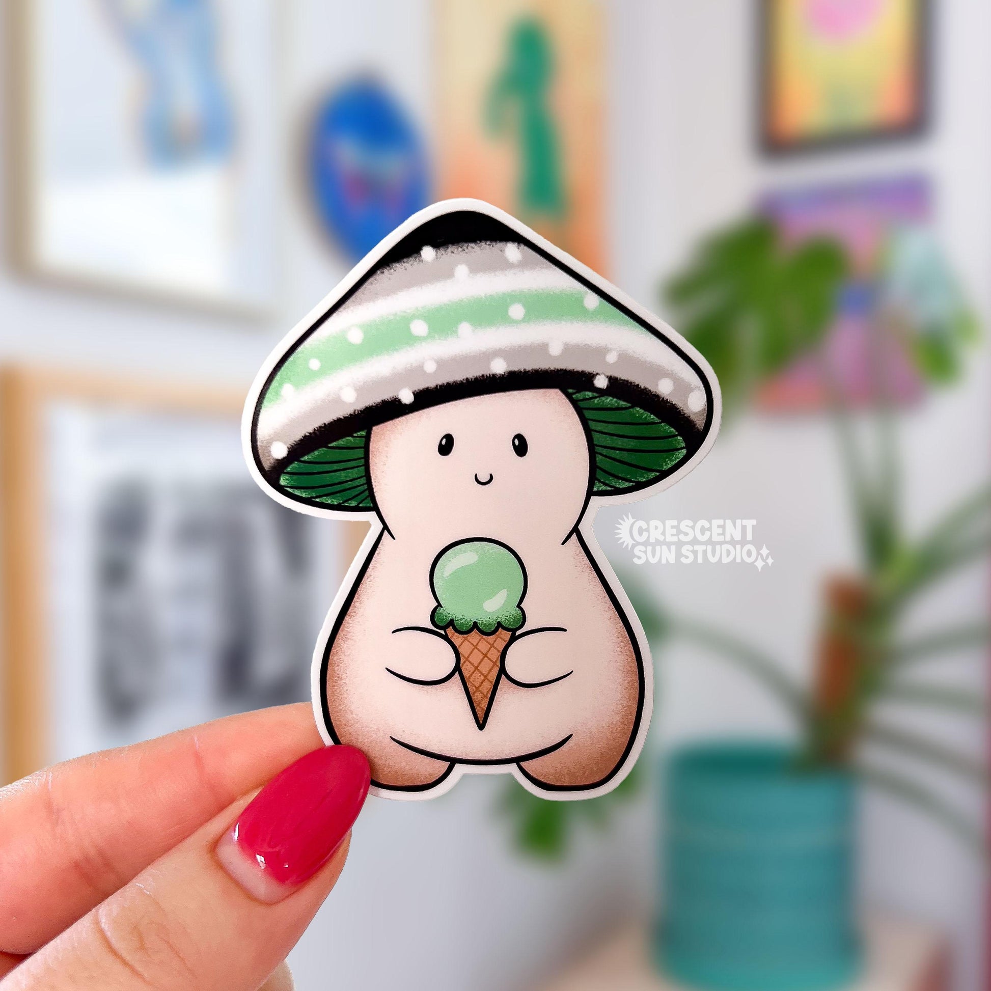 A mushroom character sticker with a black, grey, white, and green striped cap holds a green ice cream cone.