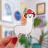 A die cut sticker of a white alpaca wearing a red mushroom cap