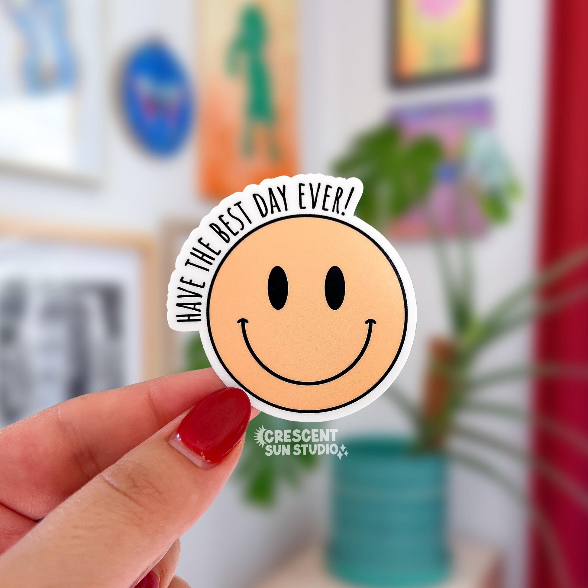 A circle-shaped yellow smiling face with outer text on the side that reads "Have the best day ever." the text is black.