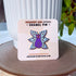 An enamel pin of a purple cat with one large pink eye at the center of its face stoically observes you. The cat has three pairs of light-colored angel wings, each wing covered with watchful pink eyes. 

