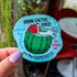 A blue die cut sticker of a cactus cup with a straw, red flower, and cactus juice surrounded by the quotes, "drink cactus juice," "nothing's quenchier," "it's the quenchiest," and "it'll quench ya!"