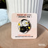 A round enamel pin depicting a black cat and a white cat curled up in a yin yang symbol. The black cat has a yellow crescent moon between her eyes and the white cat has a sun symbol between her eyes. Both smiling cats have two paws pointed outward, so you can see their pink toe pads.

In this image, the pin is displayed on a light colored card, which is propped up against a white plant pot.