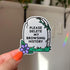 A light grey gravestone sticker with the text that reads "please delete my browsing history" in black. There is a purple daisy on the bottom left corner.