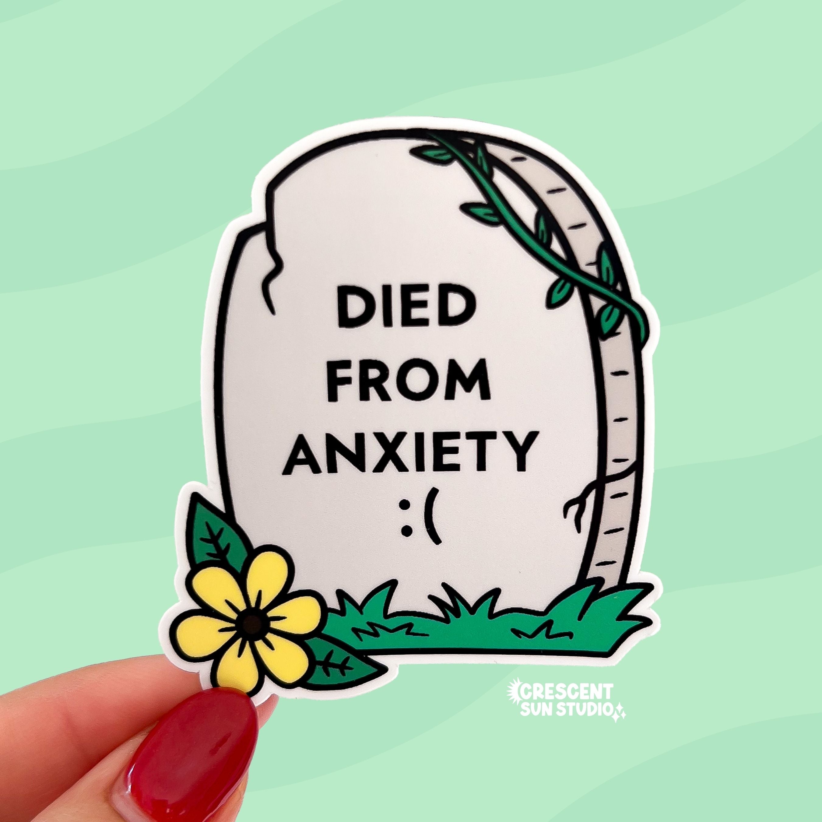 A light grey tombstone shaped sticker reads "died from anxiety :(" with a yellow flower in the bottom left corner.