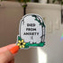 A light grey tombstone shaped sticker reads "died from anxiety :(" with a yellow flower in the bottom left corner.