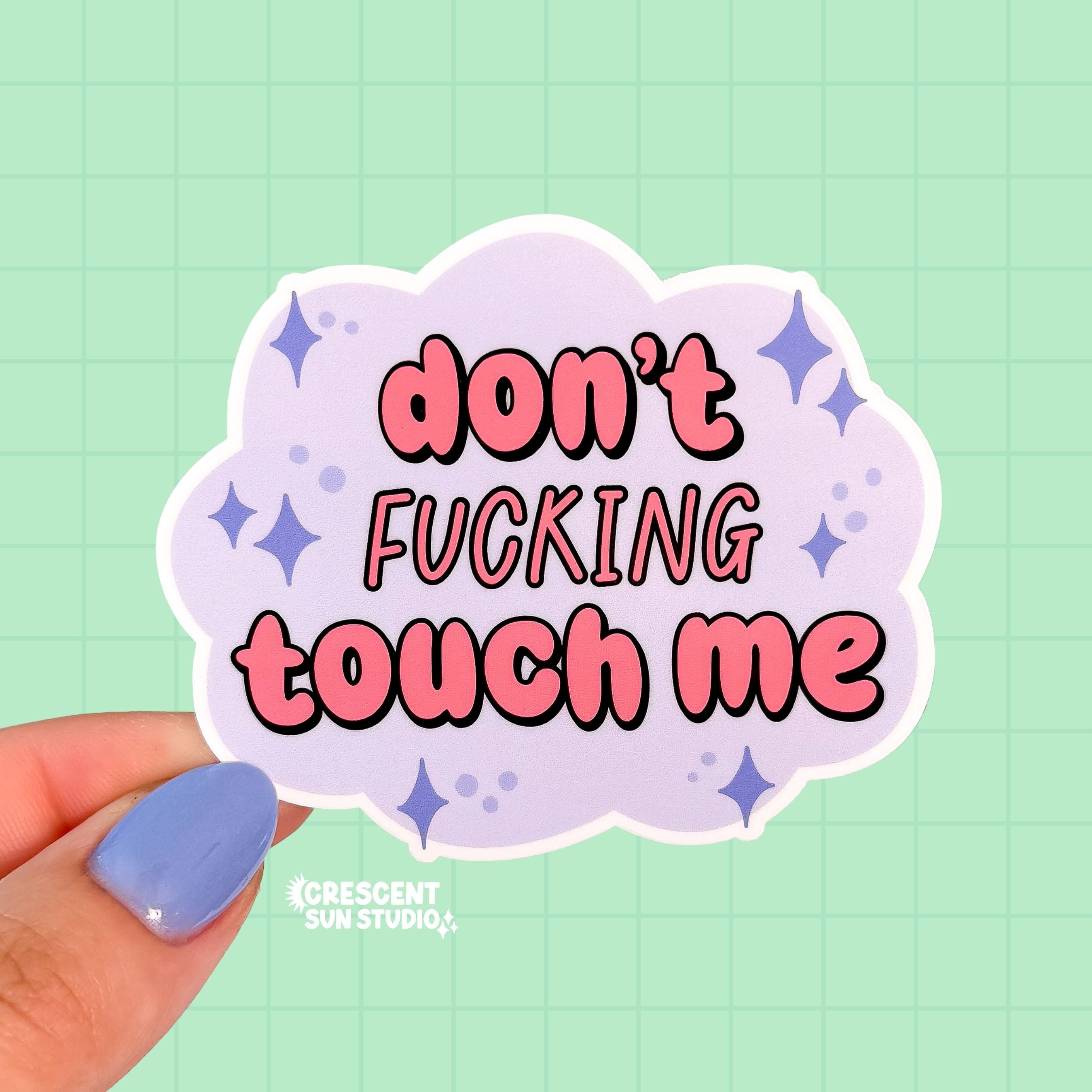 a pastel purple cloud-shaped sticker reads "don't fucking touch me" in pinky coral bubble letters. Purple stars are placed around the words.