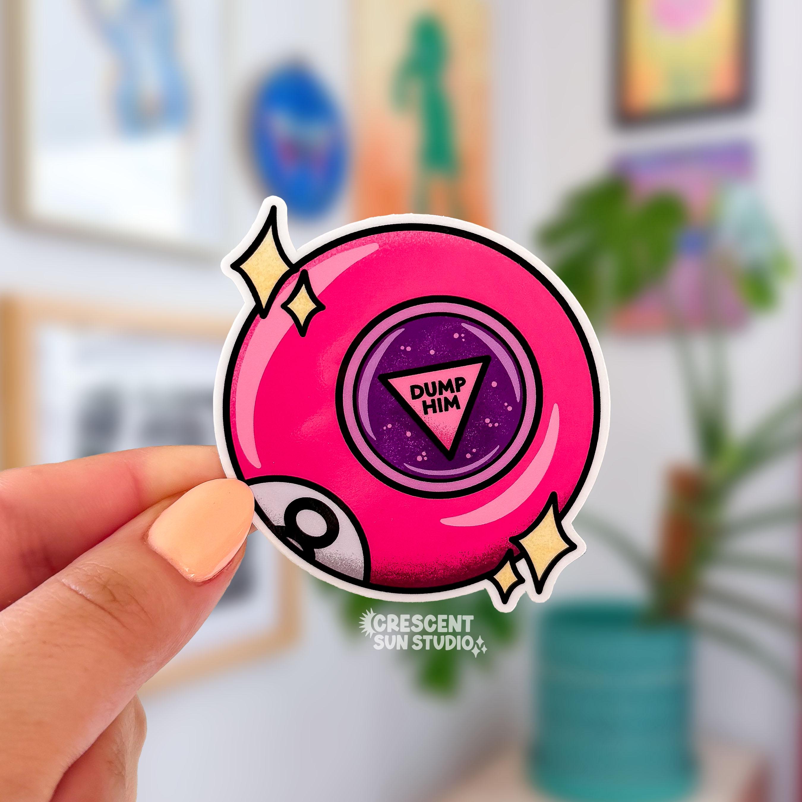 This bright pink 8 ball inspired sticker says "dump him" in the center of the ball. There are also two sets of stars on either side of the pin and part of the letter 8 is visible at the bottom left of the ball, as if curving around it.