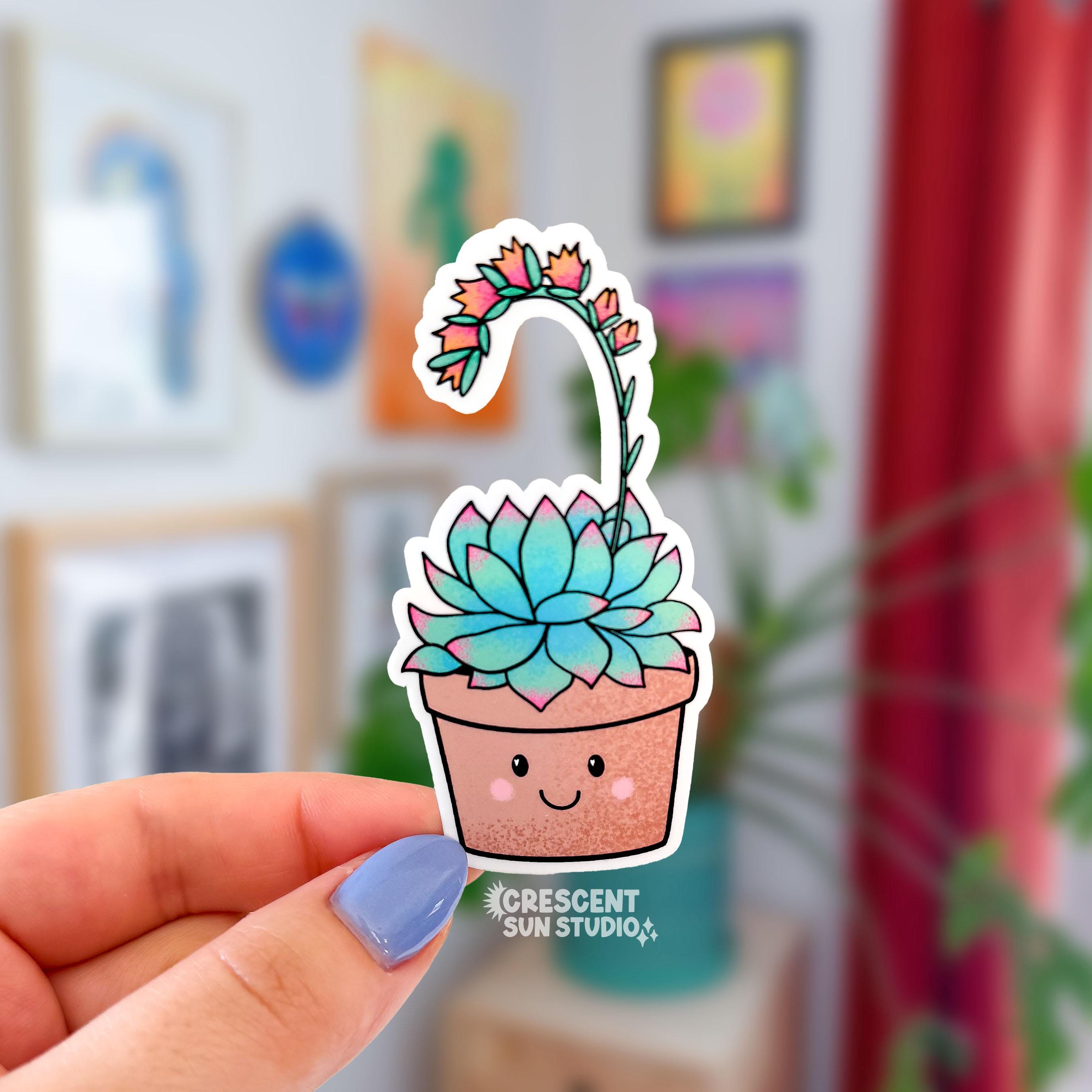 Die-cut water-resistant sticker of a smiling terracotta pot holding a green and pink succulent with a long arching bloom stem topped with small orange flowers.