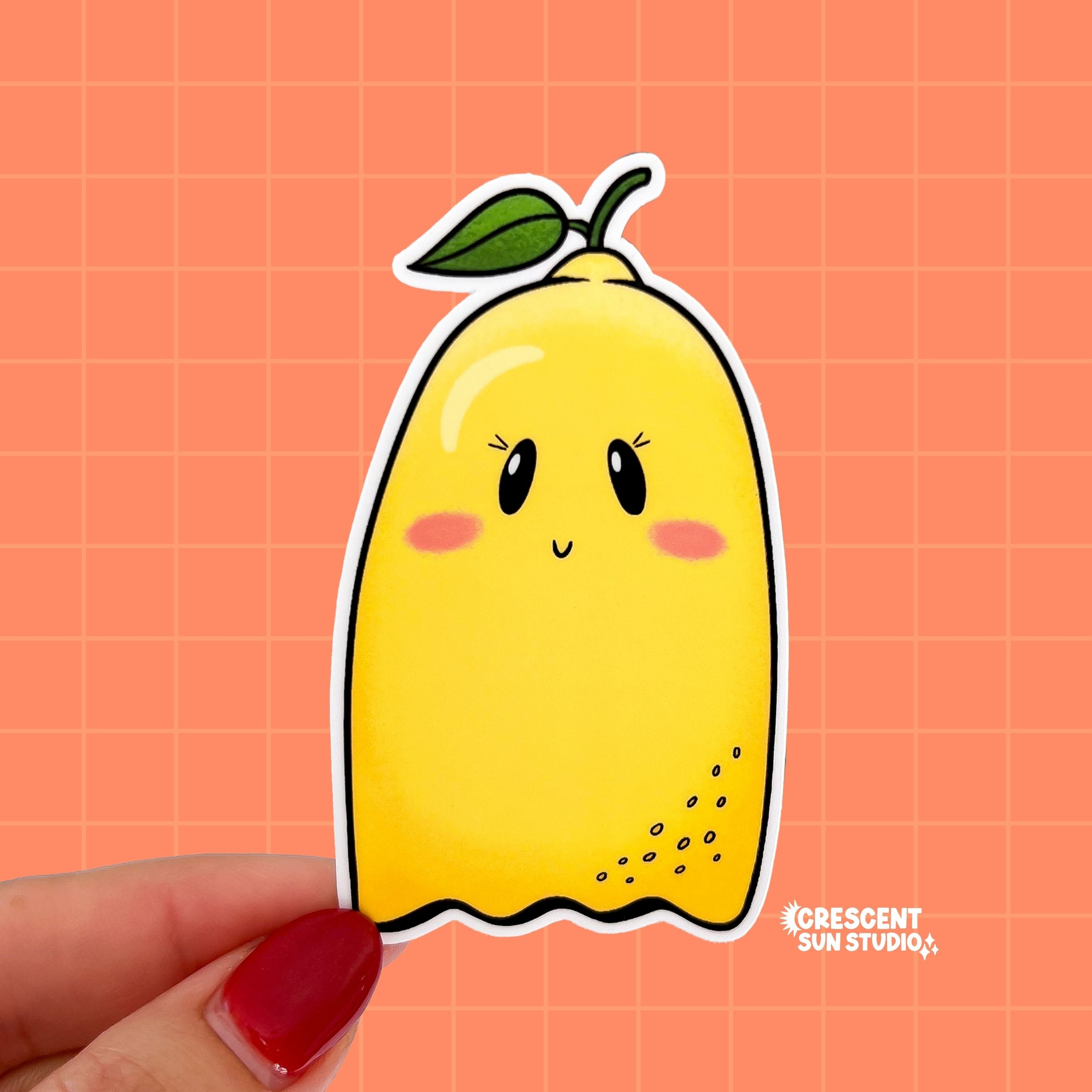 Imagine a sticker in the shape of a ghost, but also a lemon! With a little green leafy stem atop its yellow body, this ghost has a subtle smile, rosy cheeks, and eyelashes.