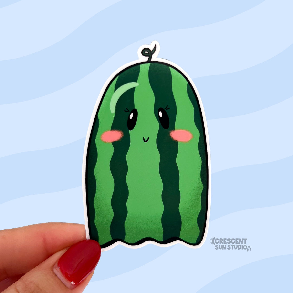 A die cut sticker in the shape of a ghost that looks like a green watermelon.