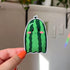 A die cut sticker in the shape of a ghost that looks like a green watermelon.