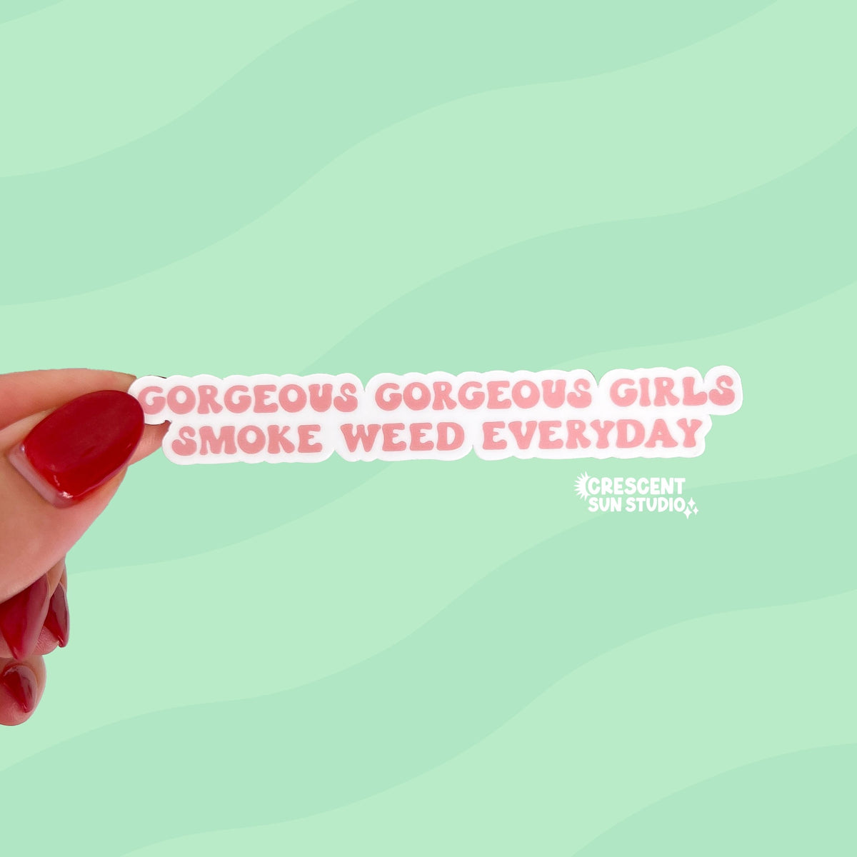 A die cut sticker of light pink bubble font reads "gorgeous gorgeous girls smoke weed everyday" written on two lines.