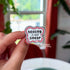 The design features bold black text surrounded by a friendly segmented worm. The text reads, "healing is not linear." The worm's head and his tail do not connect, instead, there is a tiny heart separating the two. 