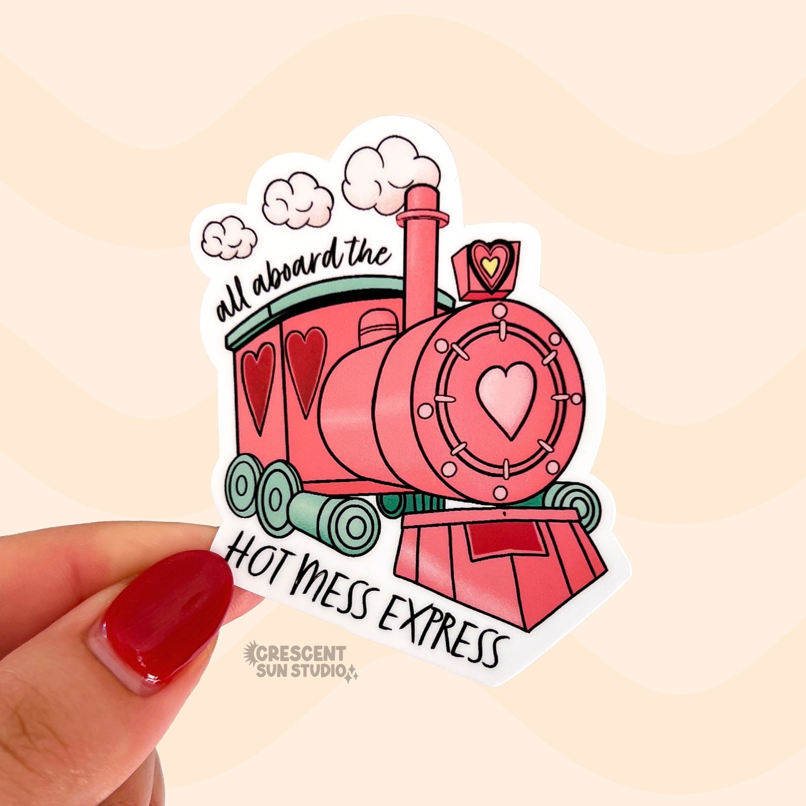 Sticker of a pink and green train with heart accents has the words "all aboard the" on the top and "hot mess express" on the bottom.