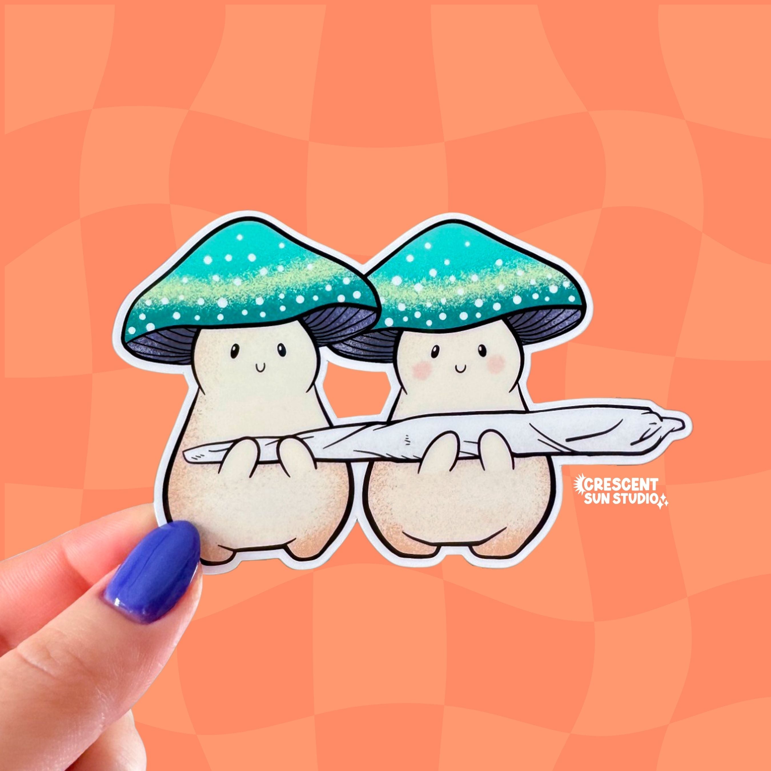 Two cream mushroom characters happily stand next to one another holding a giant joint that is larger than the two of them together! One mushroom has slightly rosier cheeks than the other. Both characters have a green mushroom cap and towards the bottom, the caps have a band of yellow and white dots that give a sparkle effect.