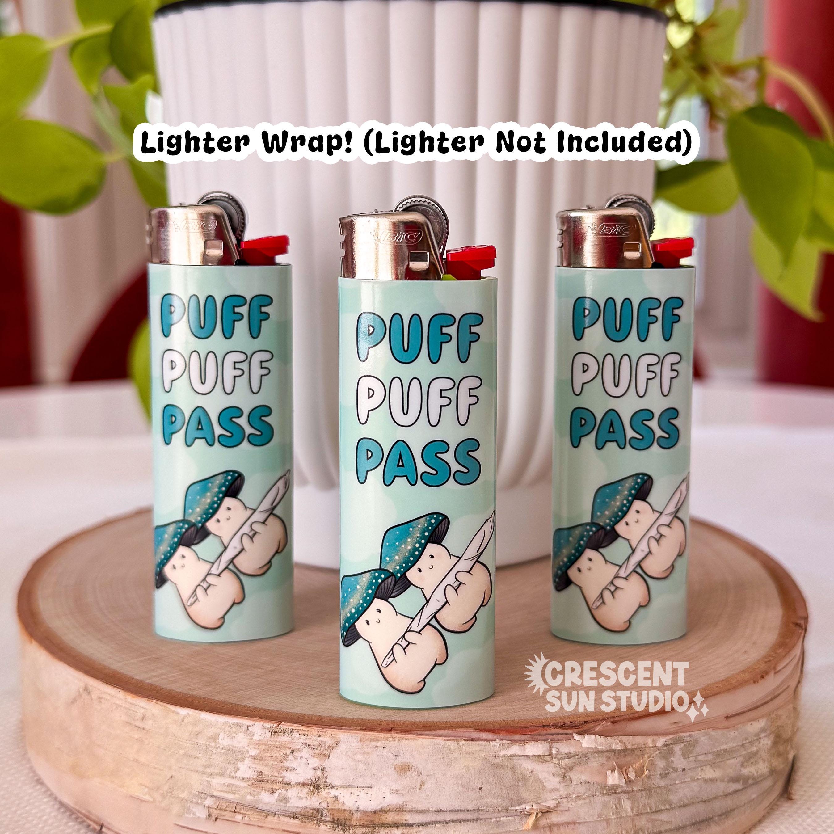 Three lighters are wrapped in a light blue design featuring two teal-capped mushroom characters sharing a joint, with 'Puff Puff Pass' in bold blue lettering. Lighter not included.