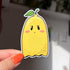 Imagine a sticker in the shape of a ghost, but also a lemon! With a little green leafy stem atop its yellow body, this ghost has a subtle smile, rosy cheeks, and eyelashes.
