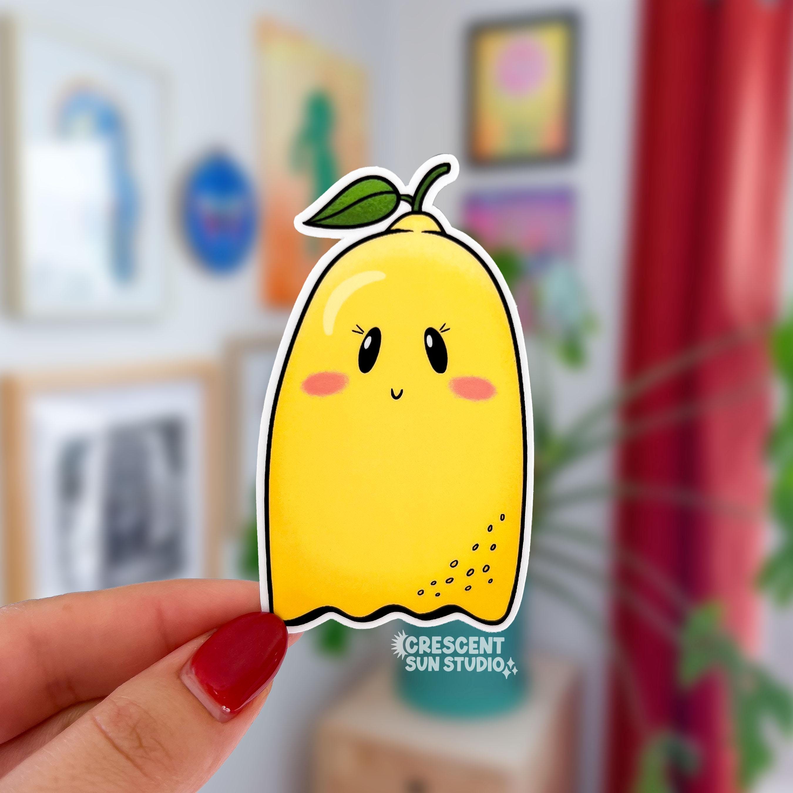 Imagine a sticker in the shape of a ghost, but also a lemon! With a little green leafy stem atop its yellow body, this ghost has a subtle smile, rosy cheeks, and eyelashes.