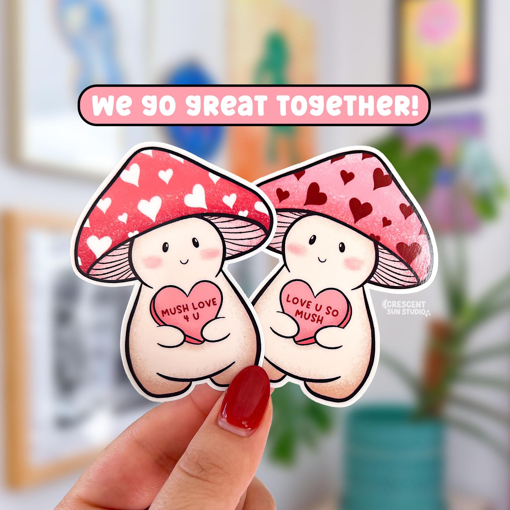 Die cut stickers of two light colored mushroom characters wearing pink and red hats with hearts. Each mushroom holds a pink candy heart. One says "mush love 4 u" and the other says "love u so mush"