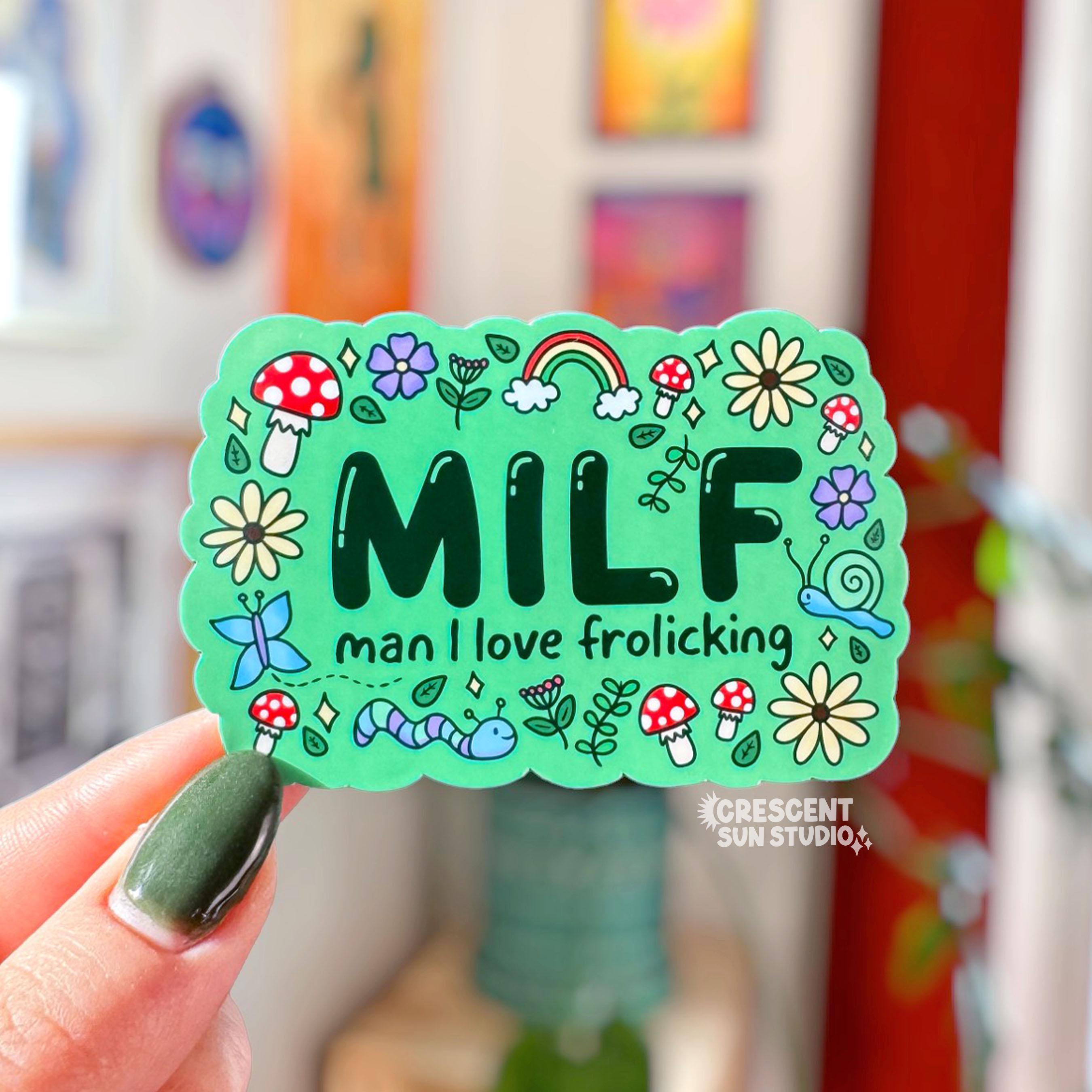 Colorful rectangle-shaped sticker with 'MILF man I love frolicking' text surrounded by doodles of mushrooms, critters, flowers and leaves.