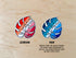 Two monstera pride flag stickers sit on a wooden background. The first depicts the lesbian flag with shades of orange, white, and pink. The second monstera sticker depicts the gay flag, with shades of dark green, teal, white, and blue.