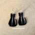 This image depicts a pair of dangle earrings. The hook for the earrings is silvertone. The earrings themselves depict a black cat silhouette lwith the full cycle of moon phases running down its spine.