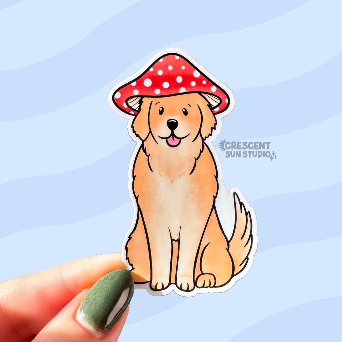 A tan colored golden retriever sticker. The dog sits with his tongue out and wears a red and white mushroom cap.