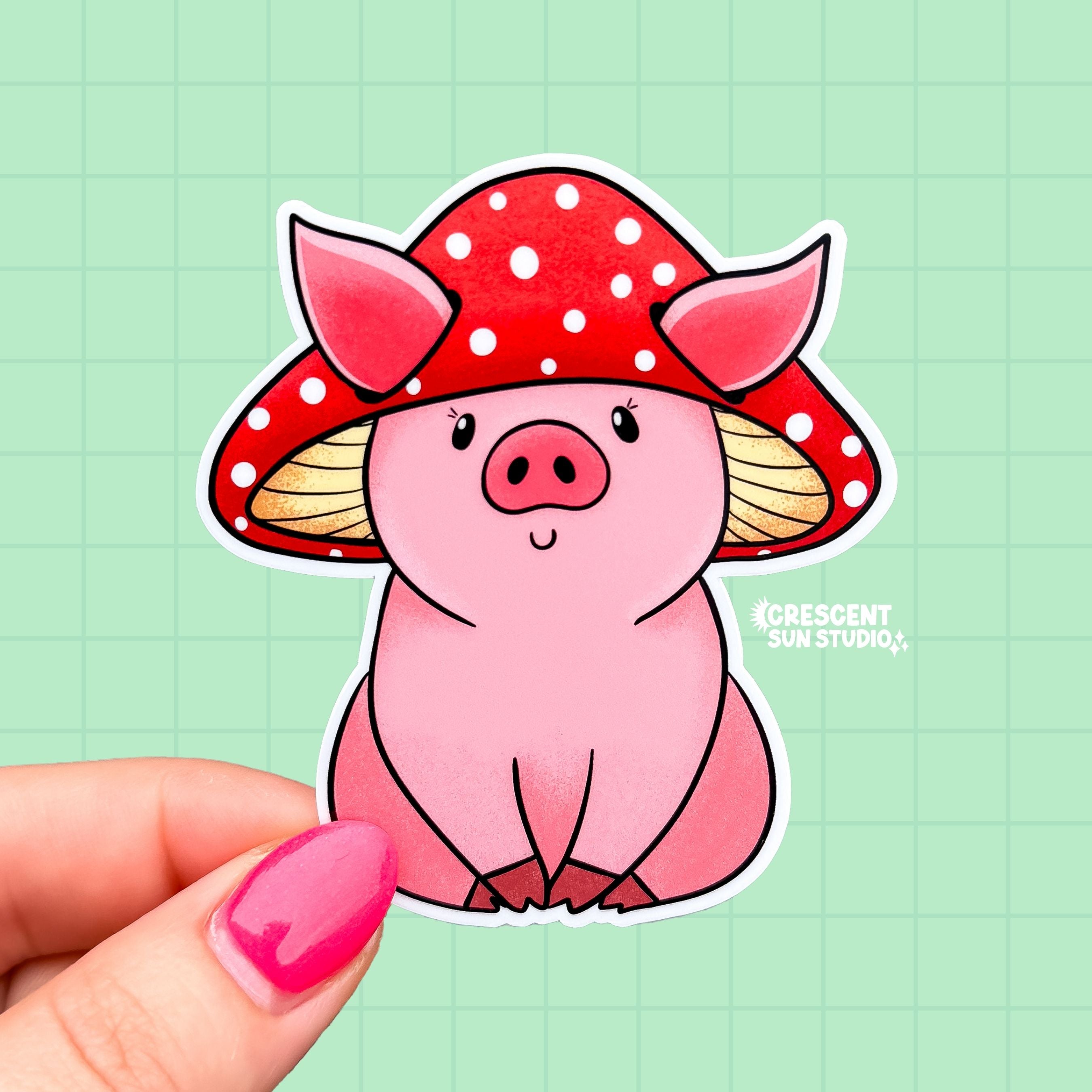 A sticker in the shape of a sitting pig wearing a mushroom hat. This pink shaded pig happily wears a red mushroom with white spots as a hat. His large pig ears stick out of the mushroom.