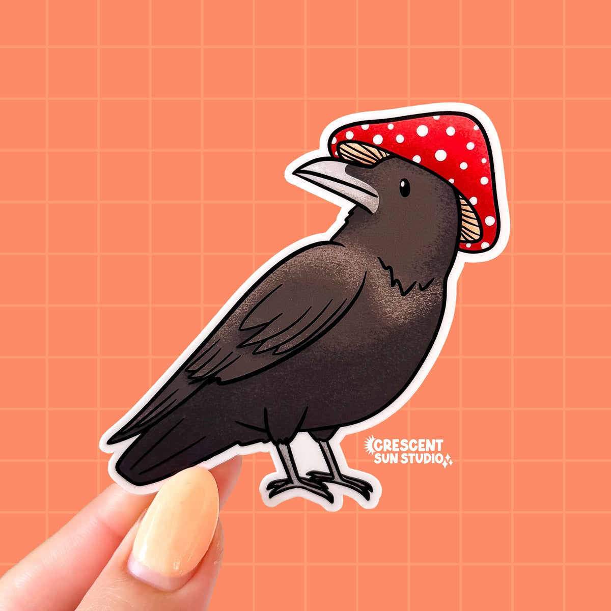 A sticker in the shape of a dark colored bird wearing a red and white mushroom for a hat.