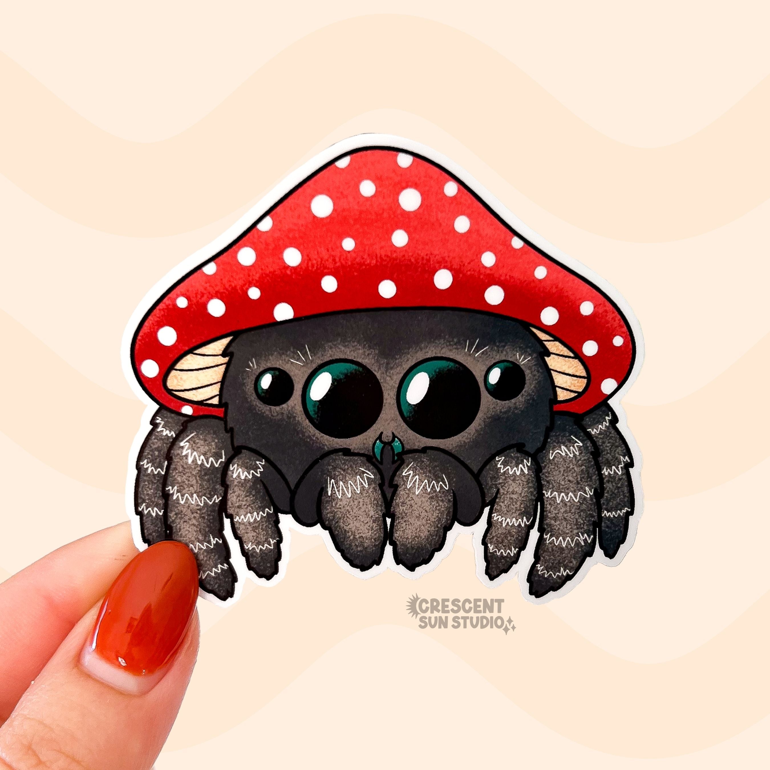 A kawaii brown jumping spider wearing a red and white mushroom cap for a hat