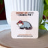 A small enamel pin in the shape of an opossum wearing a red and white mushroom hat. The pin is displayed on a light colored card.