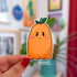 a die cut sticker in the shape of a ghost with a stem on its head is orange in color and has pink cheeks.