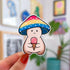 A mushroom character sticker whose cap is shaded pink, yellow, and blue. The mushroom is holding a pink ice cream cone.