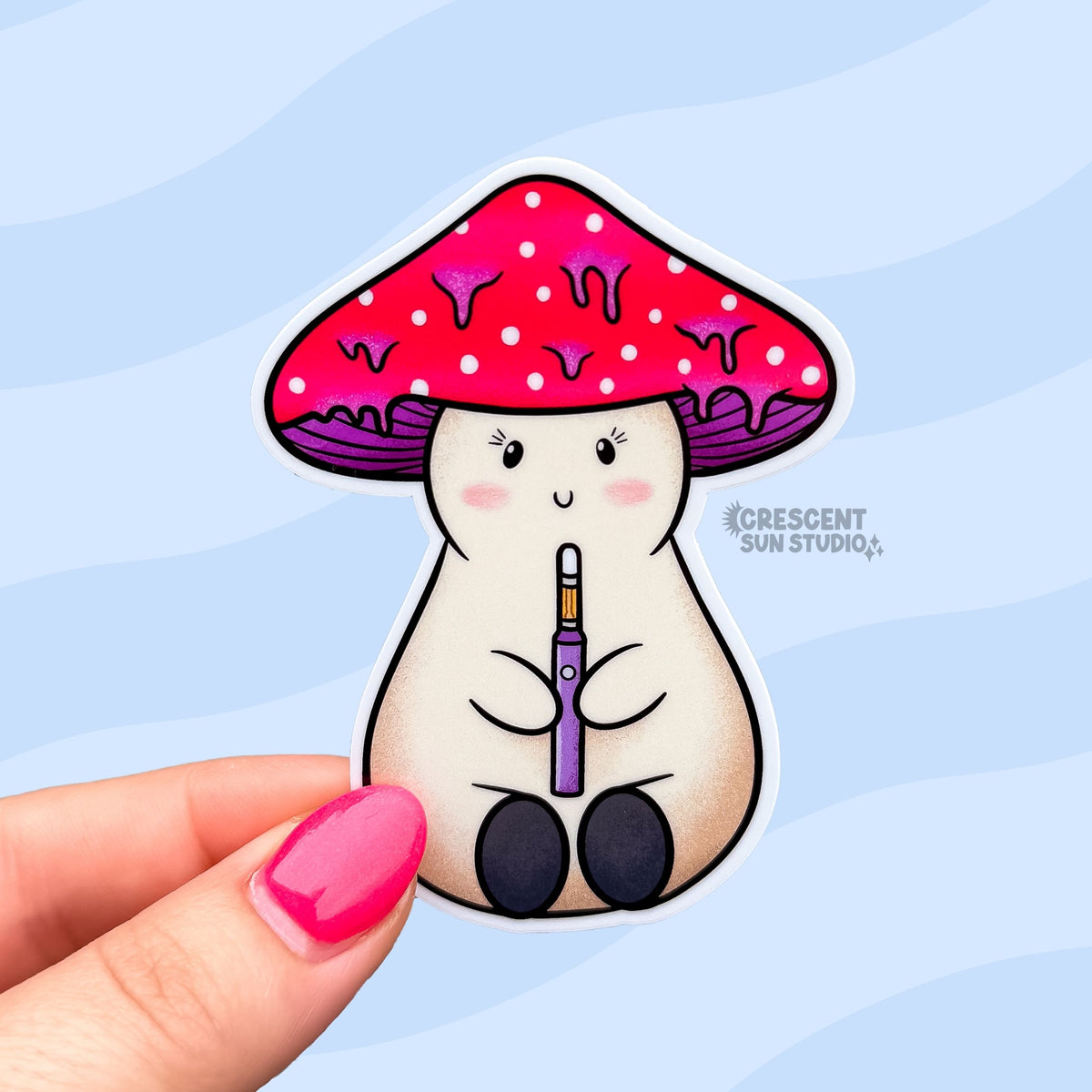 A die cut sticker of a beige stoner girl mushroom character holding a dab pen. She is smiling, has eyelashes and pink cheeks. Her mushroom cap is red and white with purple drips.