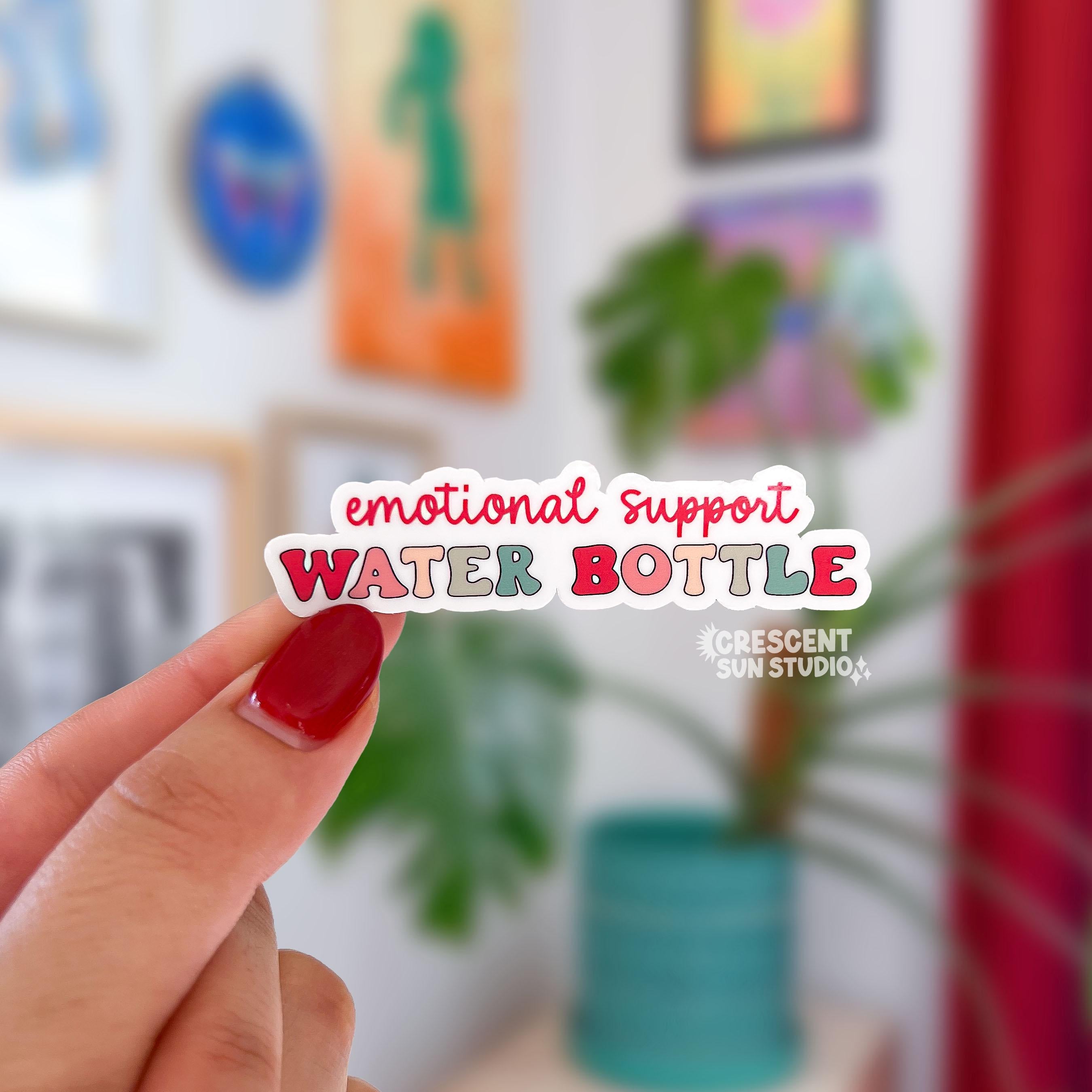 In shades of pink with some green and yellow, this die cut sticker reads "emotional support water bottle" on three lines.