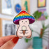A die cut mushroom sticker with the mushroom character holding an white ice cream cone and wearing a rainbow colored mushroom cap.