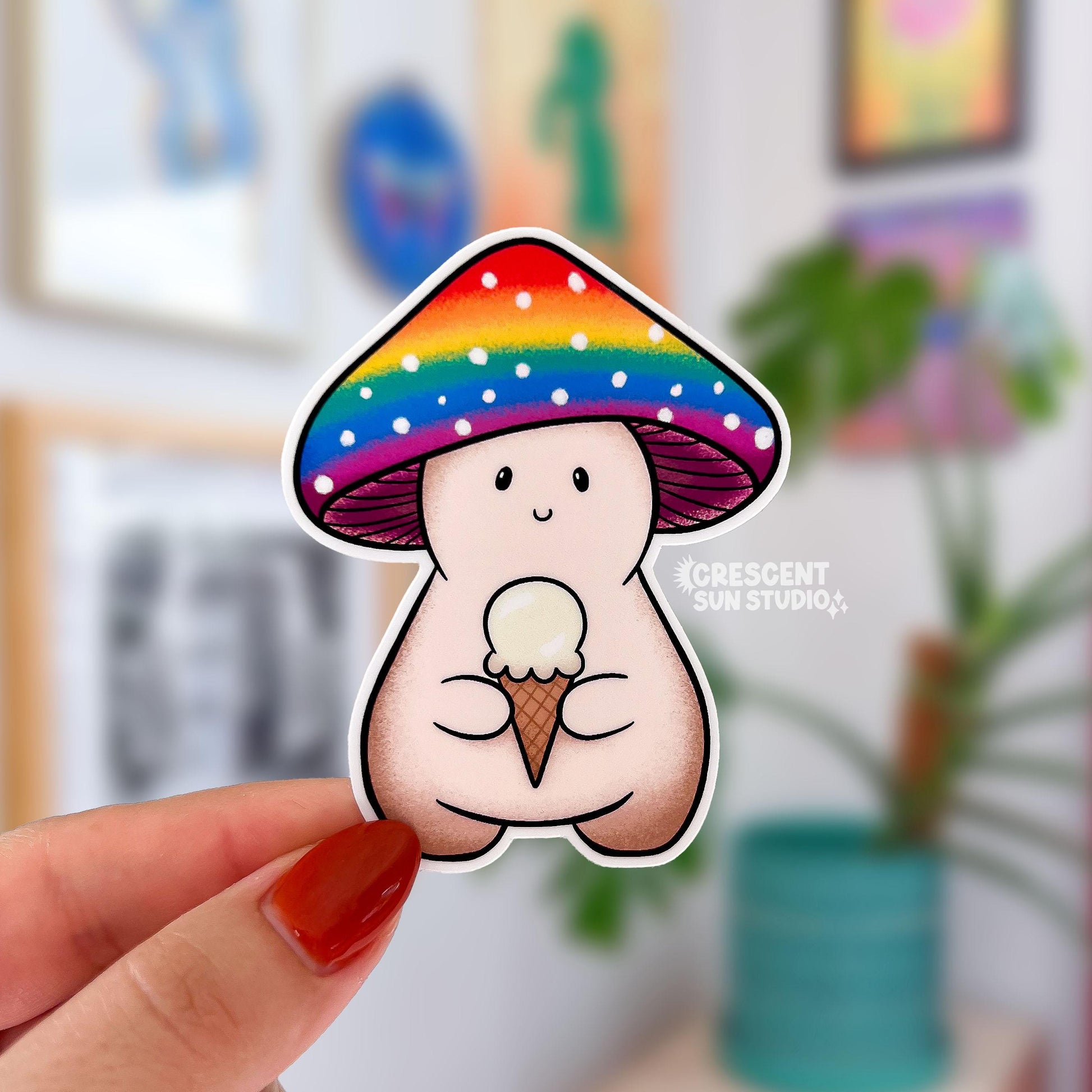 A die cut mushroom sticker with the mushroom character holding an white ice cream cone and wearing a rainbow colored mushroom cap.