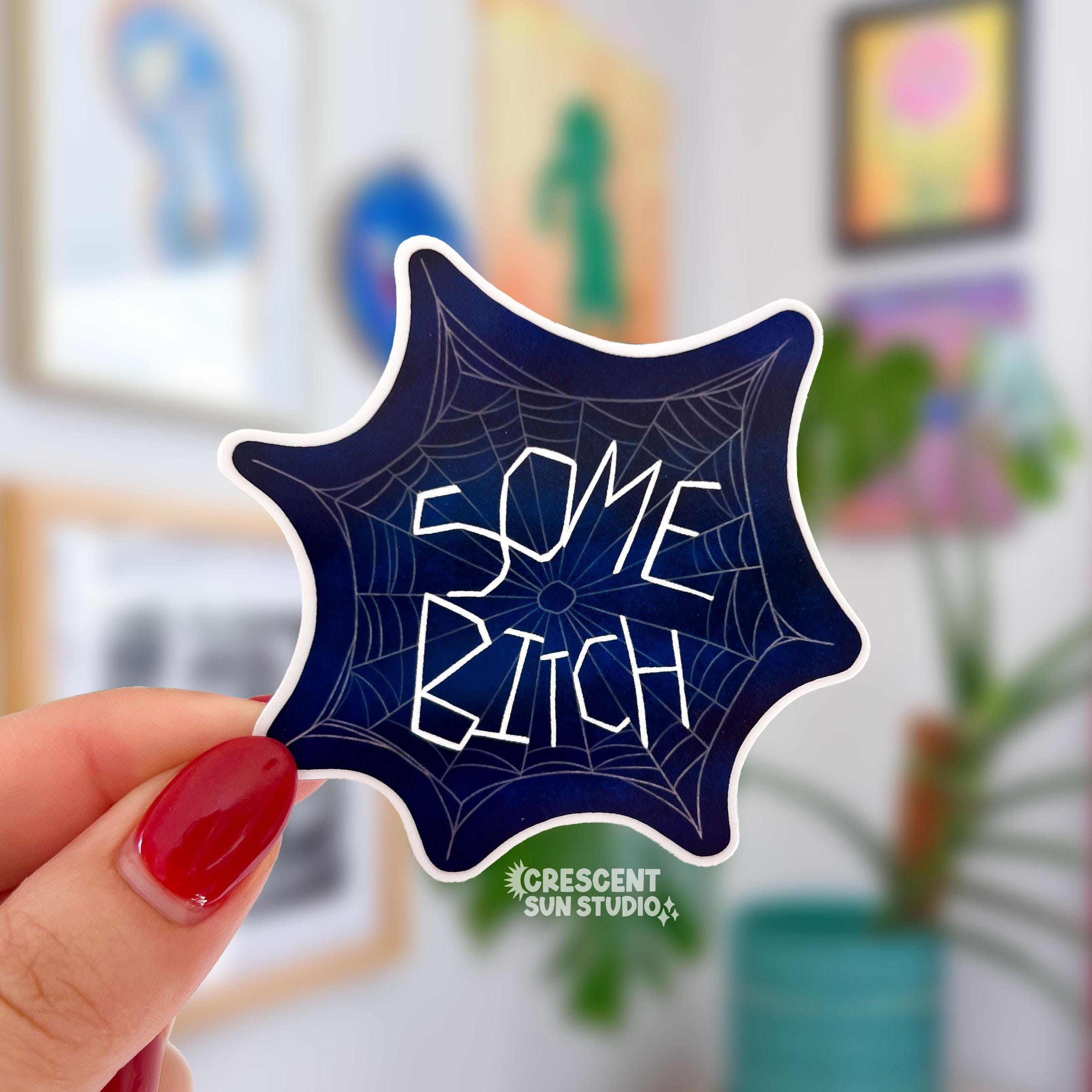 the words "some bitch" look as though they are woven into a spider web in this die cut sticker.