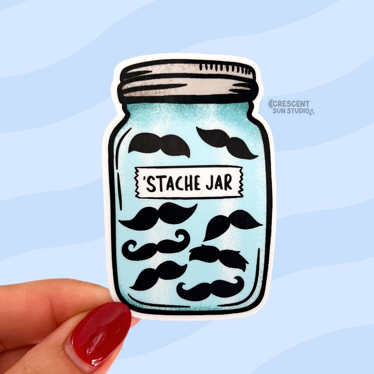 A mason jar shaped sticker full of various shaped black mustaches has a "stache jar" label on it
