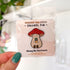An enamel pin of a plump, smiling pinky-beige mushroom character with a red mushroom cap with white spots is holding a tiny potted plant in his little mushroom arms. The pin is displayed on a small card with the text "Crescent Sun Studio, enamel pin."