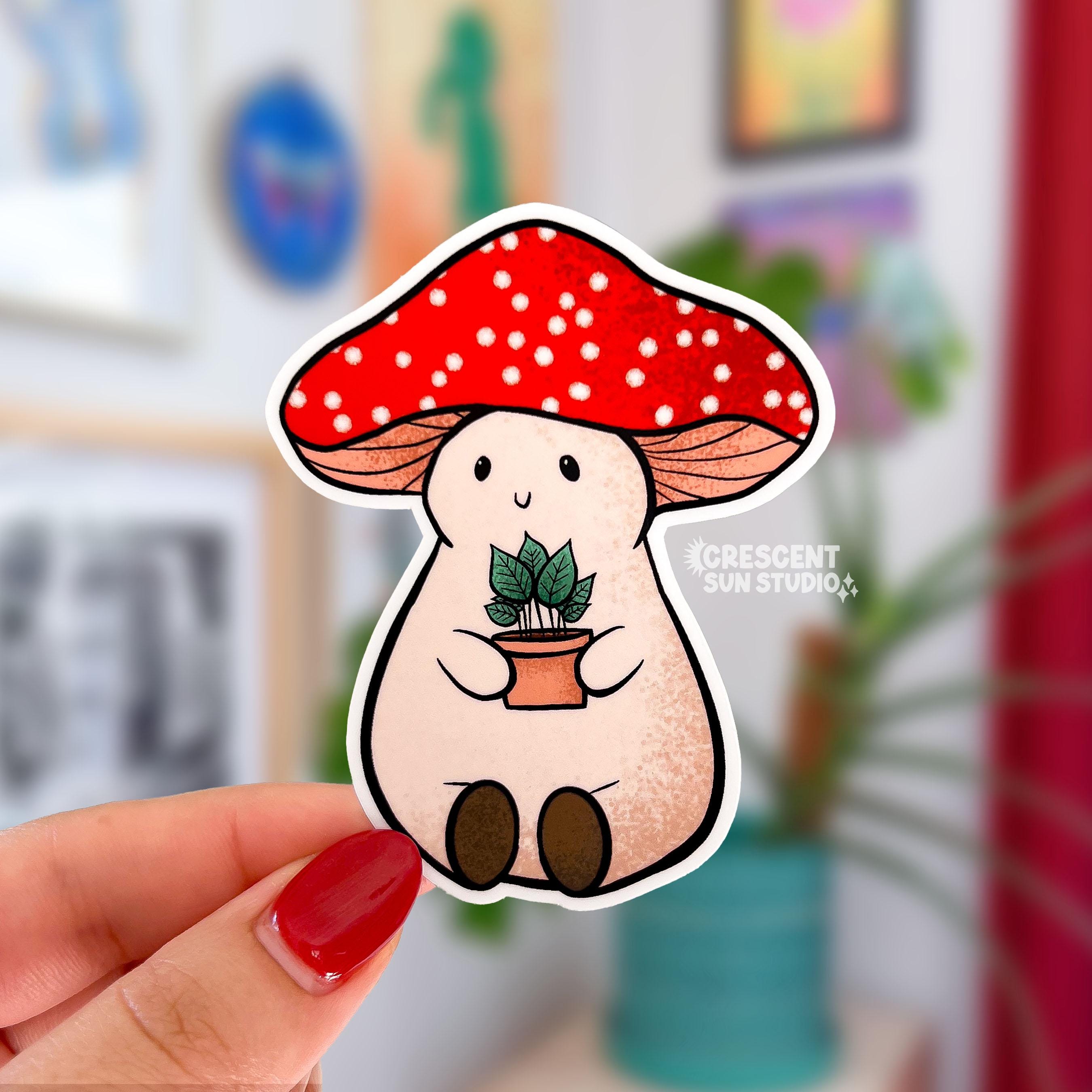 Stoney the Mushroom is a plump, smiling pinky-beige mushroom character with a red mushroom cap with white spots. Stoney is holding a tiny potted plant in his little mushroom arms. 