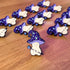 A group of pins that are all in the shape of a mushroom with an oversized mushroom cap that hooks to one side. The happy beige mushroom is holding a want with a crystal and moon on one end. His hat is purple with stars and spirals.