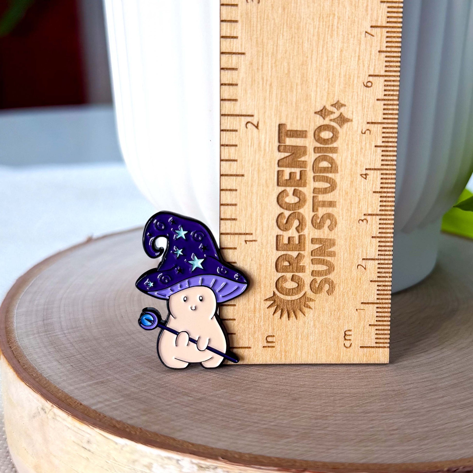 The pin stands next to a wooden ruler, showing its height of 1.35 inches.