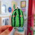 A die cut sticker in the shape of a ghost that looks like a green watermelon.